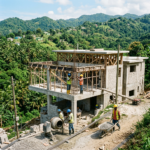 Construction workers building a multi-story concrete house in a green, hilly landscape