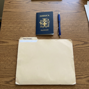 How to Request a Jamaican Birth Certificate From Overseas: 2026 Guide Jamaica passport, blue pen, and manila envelope on desk